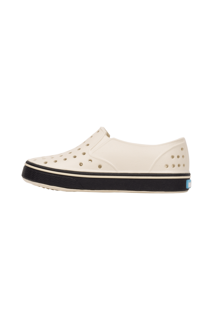 Angled view of a Native Shoes Kids Miles Kids | Bnwht/Jfyblk Footwear in Bnwht/Jfyblk
