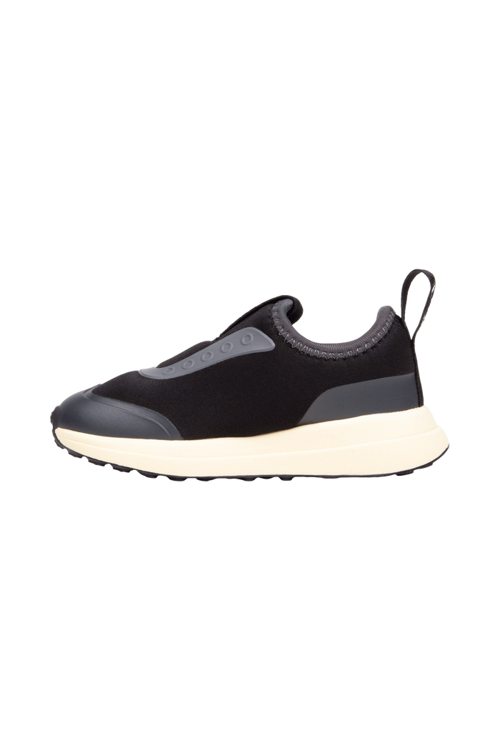 Angled view of a Native Shoes Kids Robbie Dash Kids | Jiffy Black / Tapioca Off White / Jiffy Black Footwear in Jiffy Black / Tapioca Off White / Jiffy Black